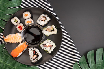 Sushi on black dish isolated on black background with copy space. Top view.