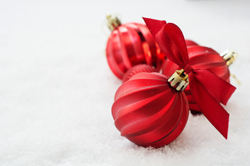 Christmas red baubles, balls isolated on snow. Winter greeting card with copy space.