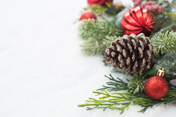 Christmas background with balls, baubles and green fir branches, pine cones, on white snow background. Winter holidays. Christmas abstract greeting card. Copy space.