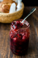 Cranberry Jam in Jar with Spoon / Cranberries Marmalade served with Bread Slices in Wicker Bowl.