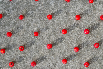 Food pattern of red Rowan berries on grey cement background, festive Christmas background