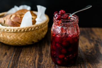 Cranberry Jam in Jar with Spoon / Cranberries Marmalade served with Bread Slices in Wicker Bowl.