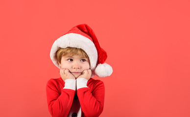 Merry christmas. Little boy in Santa Claus hat. Christmas time. Santa helper. Happy New Year. Little kid in Santa costume. Christmas kid in red hat. New Year's holiday. Cute kid boy in Santa costume.
