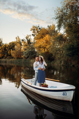 Love couple standing in a boat on quiet lake