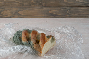 Mold on bread, a stale loaf with a large coating of mold. Close up.