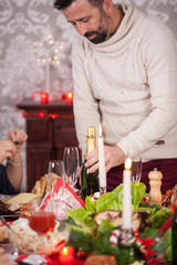 Adult man arrives with a bottle of champagne on christmas family feast