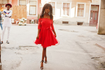 Stylish trendy afro france curly woman posed at autumn day in red dress. Black african female model.