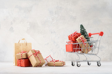 Shopping cart or trolley full of gift boxes and Christmas tree.