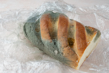 Mold on bread, a stale loaf with a large coating of mold. Close up.