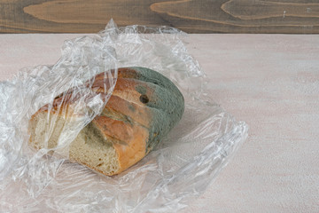 Mold on bread, a stale loaf with a large coating of mold. Close up.