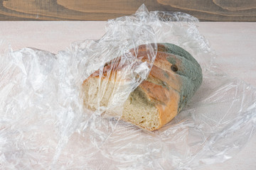 Mold on bread, a stale loaf with a large coating of mold. Close up.