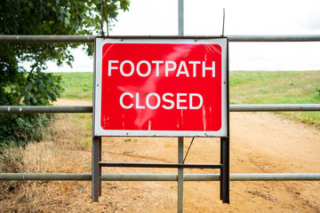 Newly erected Footpath Closed sign seen attached to a fence at a public footpath area. Due to landslip, the area is now dangerous so the path is now shut.