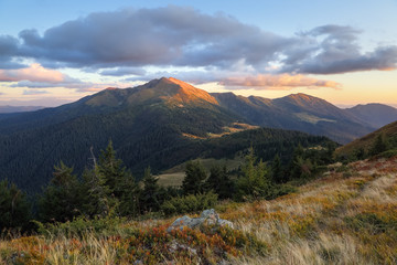 Mountain landscape with beautiful sunset, cloudy sky and orange colorful horizon. Happy fall. Touristic place Carpathian, Ukraine Europe.