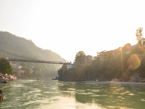 Stunning time lapse video of the Ganga river embankment with the Lakshman Jhula bridge and the Tera Manzil Temple (Trimbakeshwar) during a beautiful sunset. Rishikesh, Uttarakhand, India.