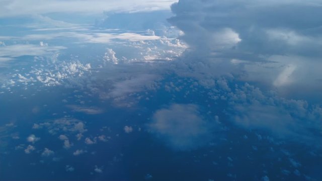 View out of  the window from airplane above beautiful multilayer white cumulus  clouds formation while flying north over Gulf of Mexico.