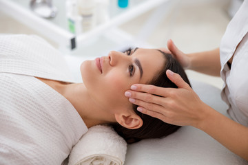 Attractive young woman having face massage at beauty salon