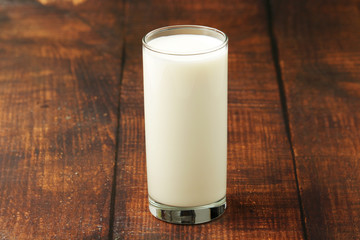 A glass with milk on a wooden rustic table