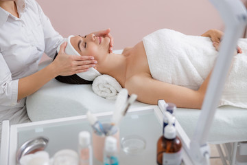 Obraz na płótnie Canvas Relaxed lady enjoying face massage at spa salon