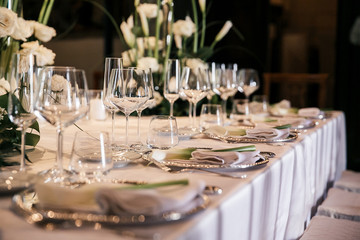 catering at a top event, glasses and flowers on the table, preparation for a significant event, beautiful dishes and glasses on the table, New Year's holiday table