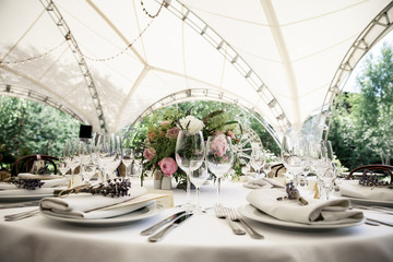 catering at a top event, glasses and flowers on the table, preparation for a significant event, beautiful dishes and glasses on the table, New Year's holiday table
