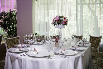 catering at a top event, glasses and flowers on the table, preparation for a significant event, beautiful dishes and glasses on the table, New Year's holiday table