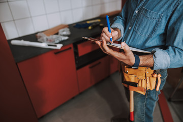 Writing on clipboard in the repaired kitchen stock photo