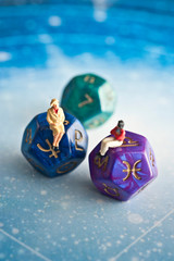 two figures - a woman and a man - sitting on dice with zodiac symbols like astrology, horoscope and love or relationship concept 