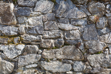 wall made of rocks. old grey stone wall on sunny day. natural background