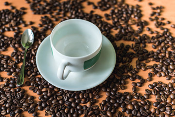 cup of coffee with beans on wooden background