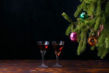 Christmas fir tree with cones decorated with multi-colored glass balls on a black background