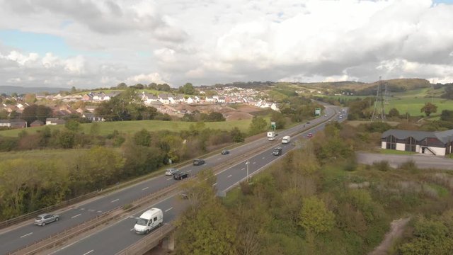 Cars driving on countryside highway in England, aerial drone shot
