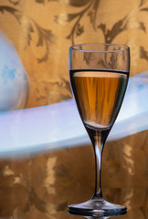 Glass goblet with drink on blurry lights background