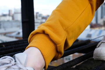 a girl in a yellow tracksuit poses on the roof of a building in the city center
