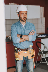 Happy repairman with arms crossed looking away