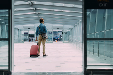 Young man with baggage leaving airport stock photo