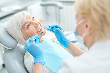Elderly patient treating her teeth at the dentist office