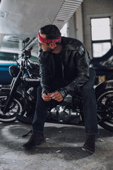 Fototapeta na wymiar Caucasian biker waiting for somebody on motorbike