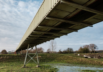 Expansive view of a quarry conveyor system seen straddling over a rural location, caring aggregates...