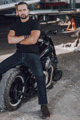 Handsome Caucasian guy sitting on new modern motorbike