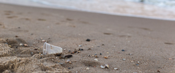 A small plastic cup on the seashore.