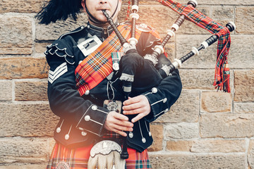 EDINBURGH, SCOTLAND, 24 March 2018 , Scottish bagpiper dressed in traditional red and black tartan...