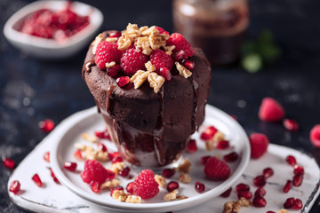 Raspberry mug cake in a glass on dark background