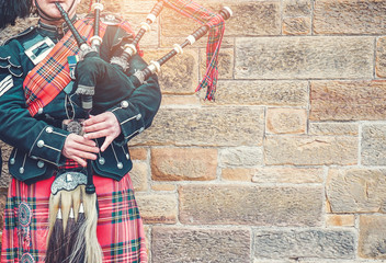 EDINBURGH, SCOTLAND, 24 March 2018 , Scottish bagpiper dressed in traditional red and black tartan...