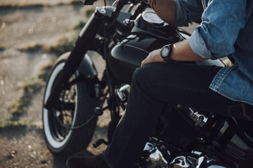 Fototapeta na wymiar Caucasian guy is resting on his motorcycle