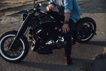 Fototapeta na wymiar Caucasian male having rest on his motorcycle