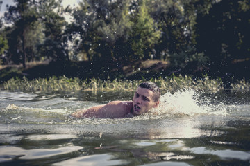 The young man swimming in the river