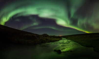 Fototapeta na wymiar Northern lights with reflection in river, North Iceland