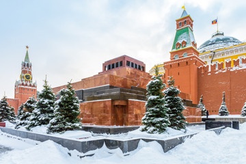 Moscow Red Square in winter, Russia. Lenin's Mausoleum by Moscow Kremlin under snow. This place is famous tourist attraction of Moscow city. Center of Moscow during snowfall. Concept of Russian frost.