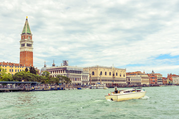 Venice cityscape in summer, Italy. San Marco embankment with Campanile and Doge's Palace. This place is main tourist attraction of Venice. Panorama of waterfront of Venice. Vintage retro style photo.