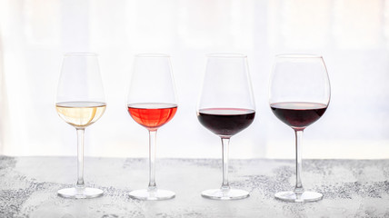 Glasses with different wine bordeaux, red, rose  and white on white background. Beautiful wine variety concept.